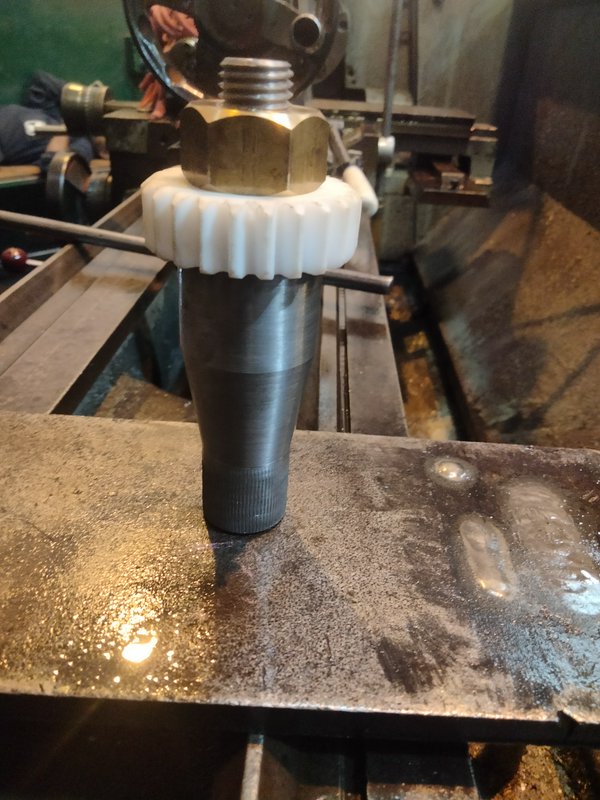 Stacked machined component assembly resting on a worn metal lathe workbench in a machine shop