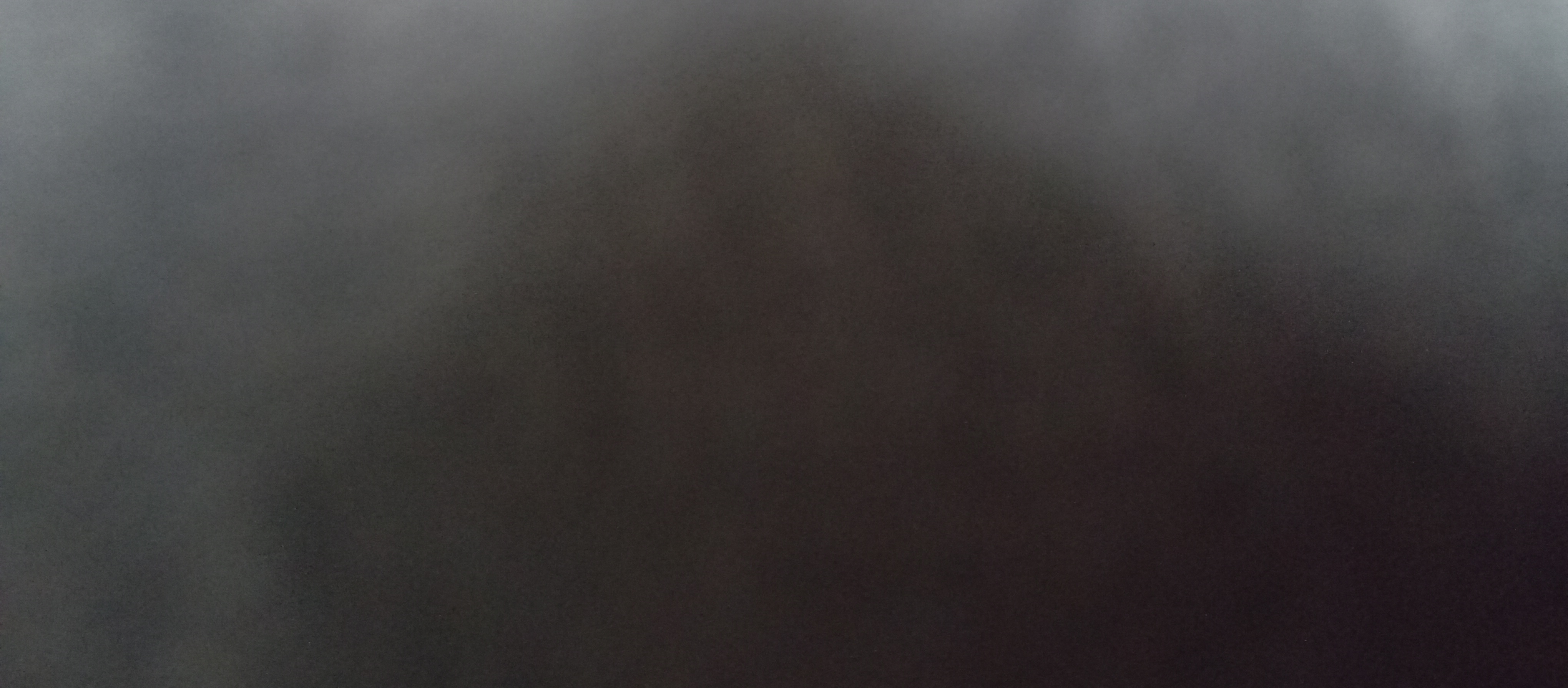 Grainy foggy abstract gradient background shifting from pale gray edges to deep warm dark brown center
