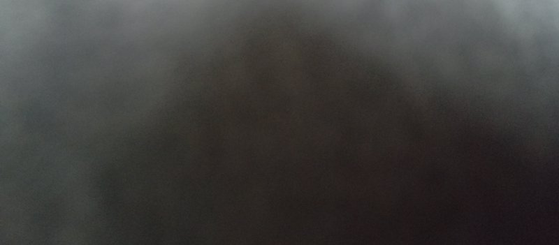Grainy foggy abstract gradient background shifting from pale gray edges to deep warm dark brown center
