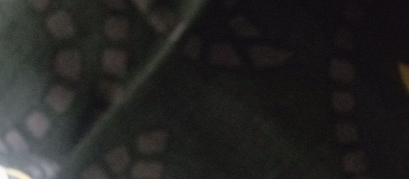 Dark blurry low-light frame with soft round out-of-focus bokeh lights and thin diagonal linear element