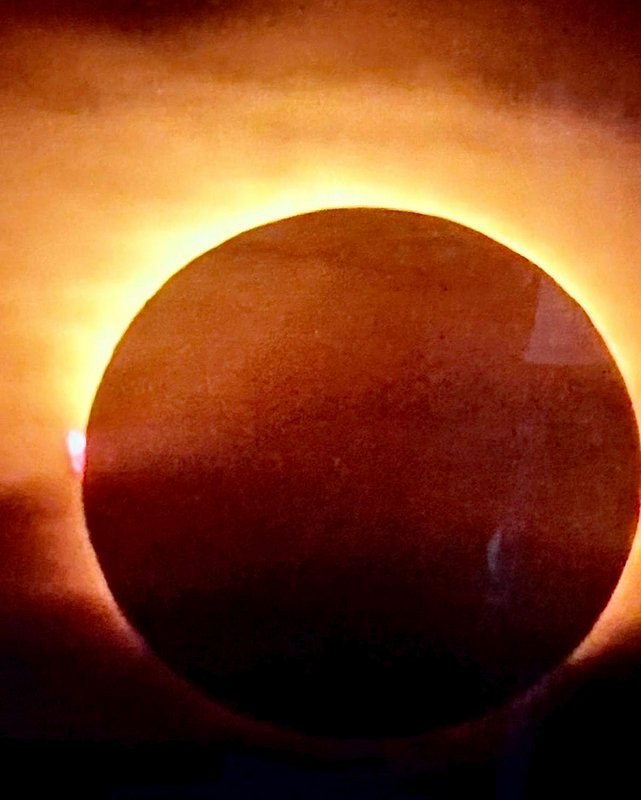 Annular solar eclipse showing a glowing golden ring of fire around the obscured sun