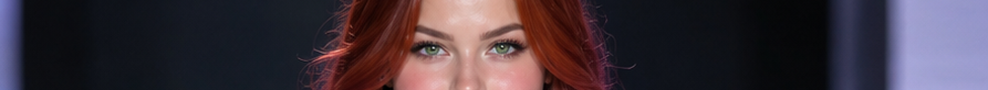 Close-up of a woman's vivid green eyes framed by wavy red hair against a dark studio background