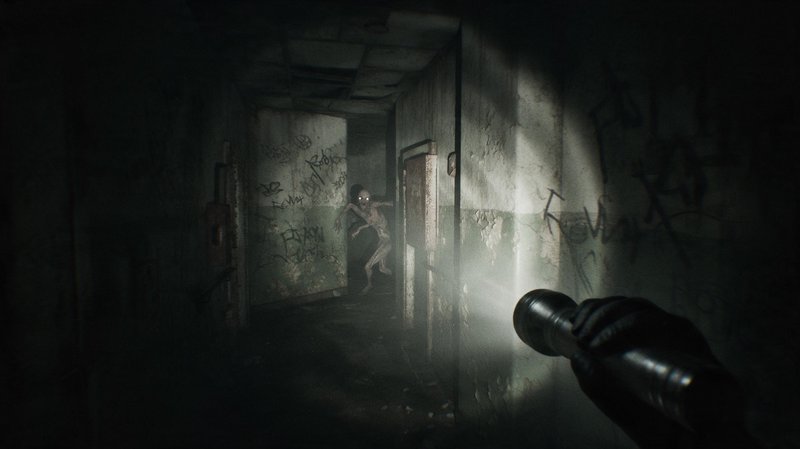 First person flashlight view revealing a glowing-eyed humanoid monster in a decayed abandoned hallway