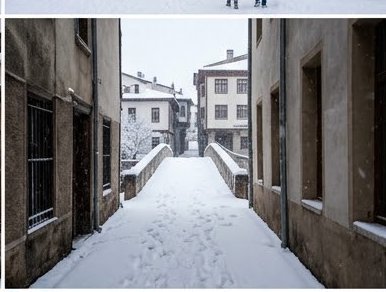 Snow-covered arched stone bridge sits at the end of a narrow old town alley during gentle snowfall