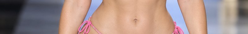Close-up of a person's toned midsection wearing a bright pink tie-side string bikini bottom