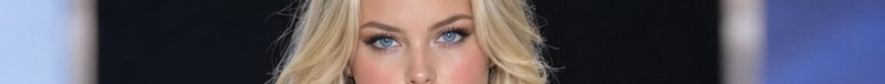 Extreme cropped closeup showing the vivid bright blue eyes of a woman with wavy blonde hair