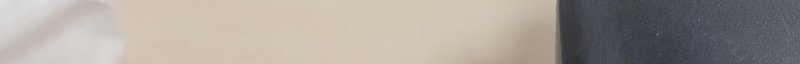 Blurred abstract horizontal banner strip with soft beige, dark grey and pale neutral sections
