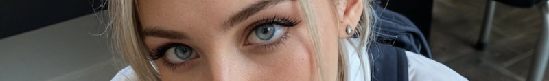 Extreme close up of a blonde woman's pale bright blue eyes looking directly at the camera