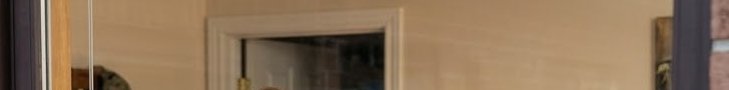 Cropped panoramic interior shot of a beige wall with a white trimmed residential doorway