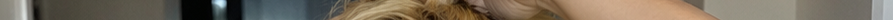 Scan line glitch distorted closeup showing partial blonde hair, skin, and blurred dark background