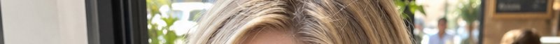 Close up of dimensional highlighted blonde hair in a sunlit casual cafe interior