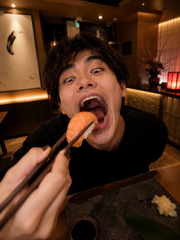 Person about to bite salmon nigiri with chopsticks in a warm restaurant setting.