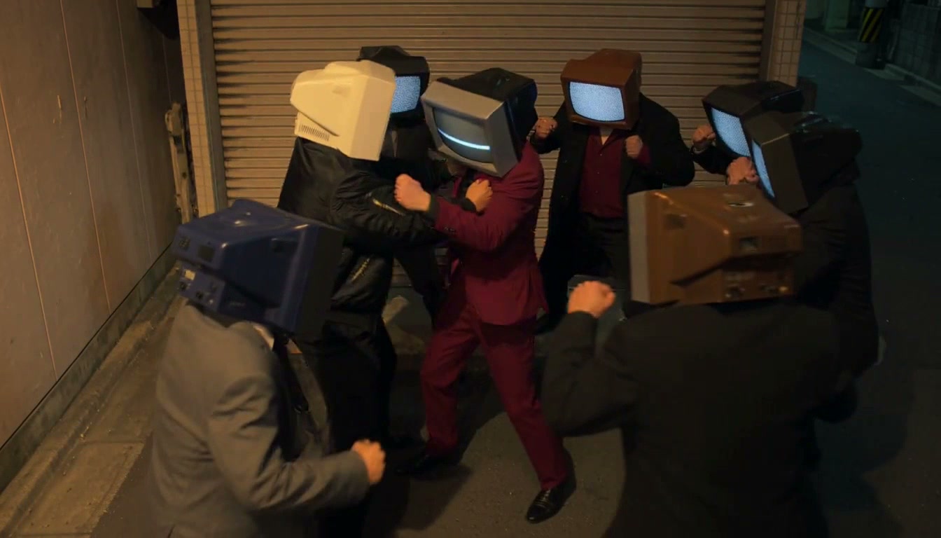 Group of people wearing vintage CRT TV heads face off in a tense nighttime urban alley