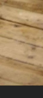 Close-up of a light wooden tabletop with visible grain and knots.