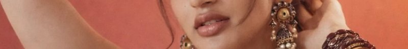 Close-up of a woman's lips with elaborate traditional jewelry and warm-toned background