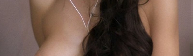 Close-up of a person with long dark hair in a back view, wearing white earphones.