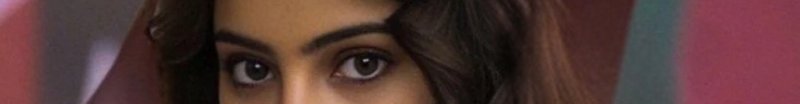 Close-up of a woman’s eyes with a partial hijab and colorful background.