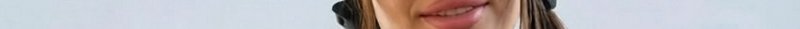 Close-up of a woman's lips and lower face with earrings.