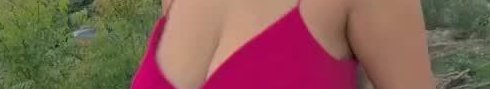 Close-up of a person wearing a bright pink top outdoors.