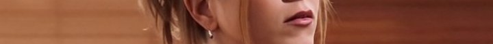 Close-up of a woman's lower face and ear featuring pink lipstick and a small hoop earring.