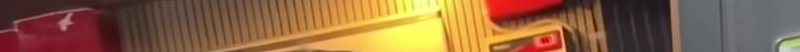 Blurred interior shelf with yellow lighting and stacked boxes in a storage area.