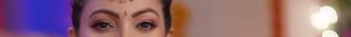 Close-up of an Indian woman with traditional makeup and a bindi.