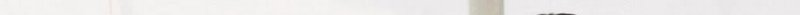 A pale, light-colored surface with subtle vertical lines and minimal texture.