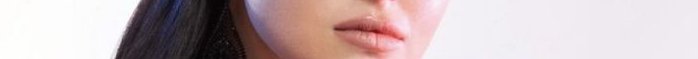 Close-up portrait of a person’s lips with pink lipstick and blue hair.