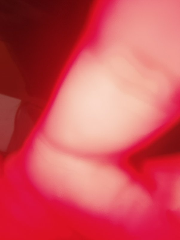 Close-up abstract pink-red blur with soft gradients and light shapes.