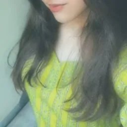 Close-up of a person with long dark hair wearing a bright yellow top.