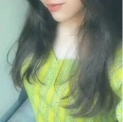 Soft focus cropped close-up of a woman with long dark wavy hair wearing a bright lime green knit ...