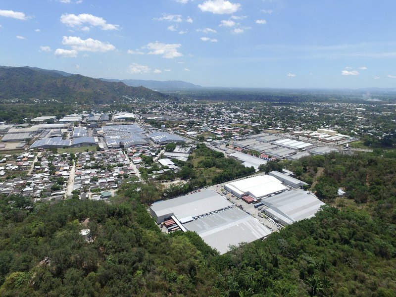 Aerial view of a suburban industrial park with large warehouses and surrounding greenery.