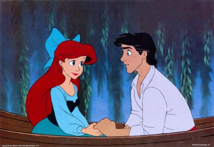 Ariel and Prince Eric sit in a wooden rowboat, holding hands in a moonlit scene.