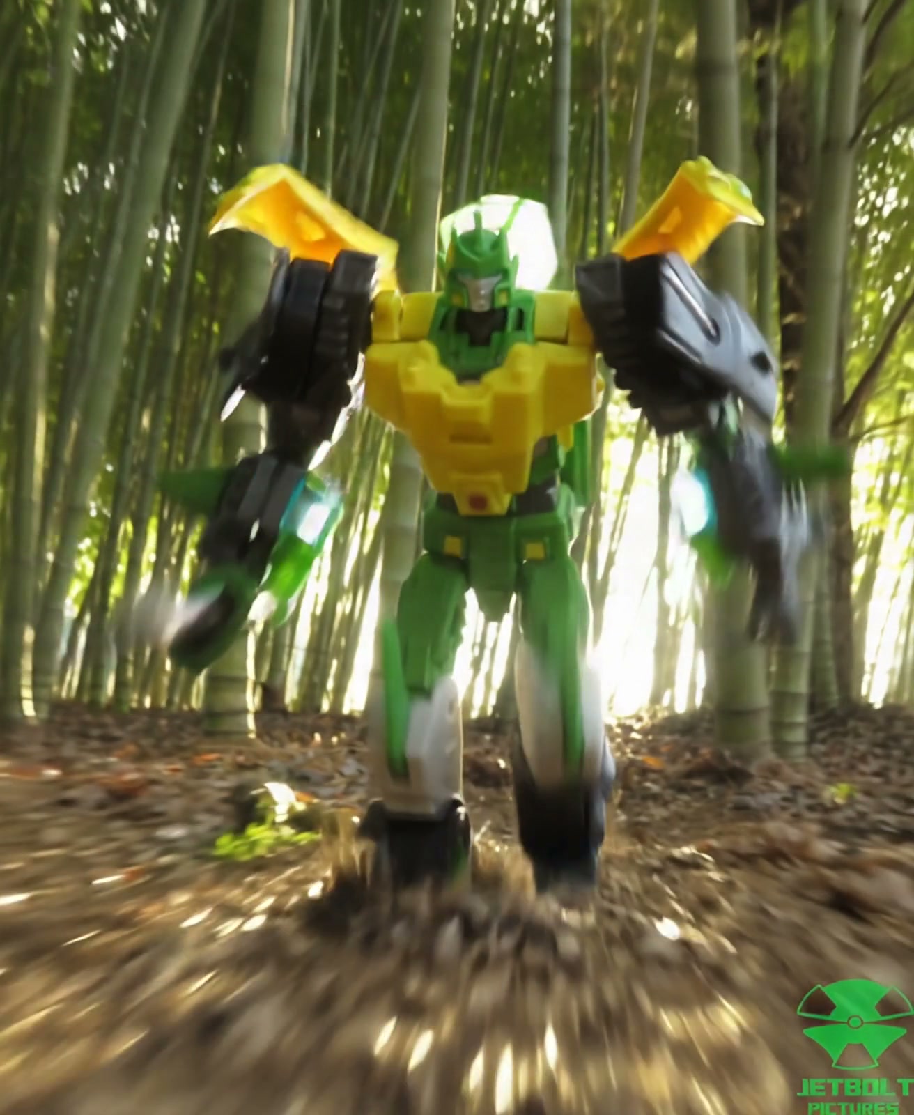 Green and yellow robot action figure in a bamboo forest with motion blur.