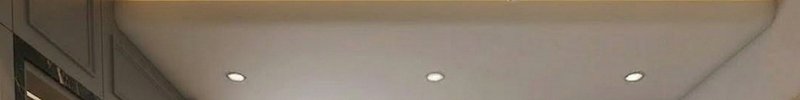 White ceiling with three small recessed round lights (downlights).