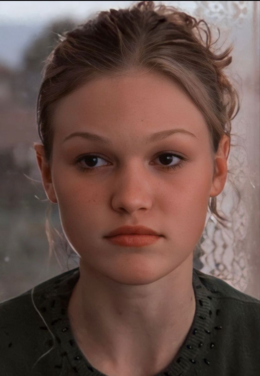 Close-up portrait of a young woman with a soft, natural look by a window.