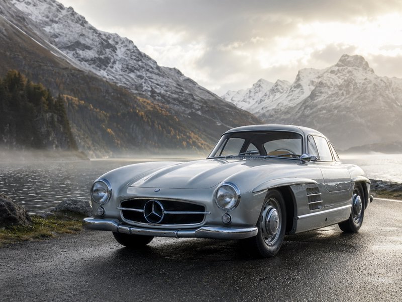 Silver vintage Mercedes-Benz sports car parked by a mountain lake