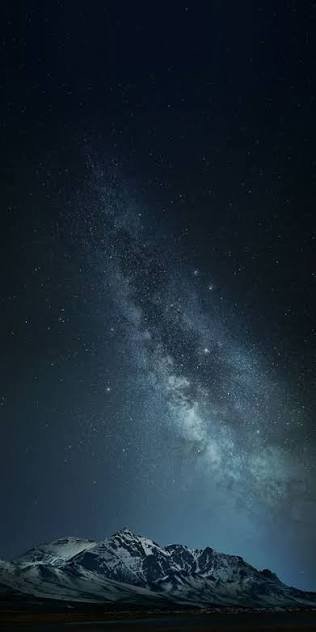 Milky Way over snow-capped mountains under a starry night sky