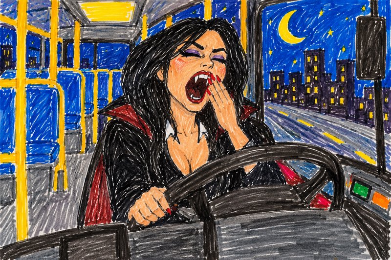 Tired female vampire bus driver yawning behind the wheel of a night city bus