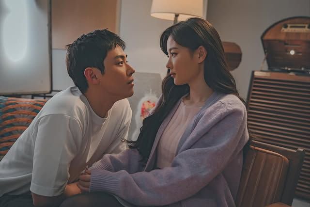 Couple sharing an intimate moment in a cozy living room with warm lighting.