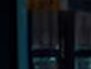 Dark futuristic scene with blue neon vertical strips and shadowy panels.