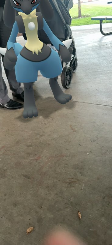 Augmented reality Lucario character standing on a concrete park pavilion floor.