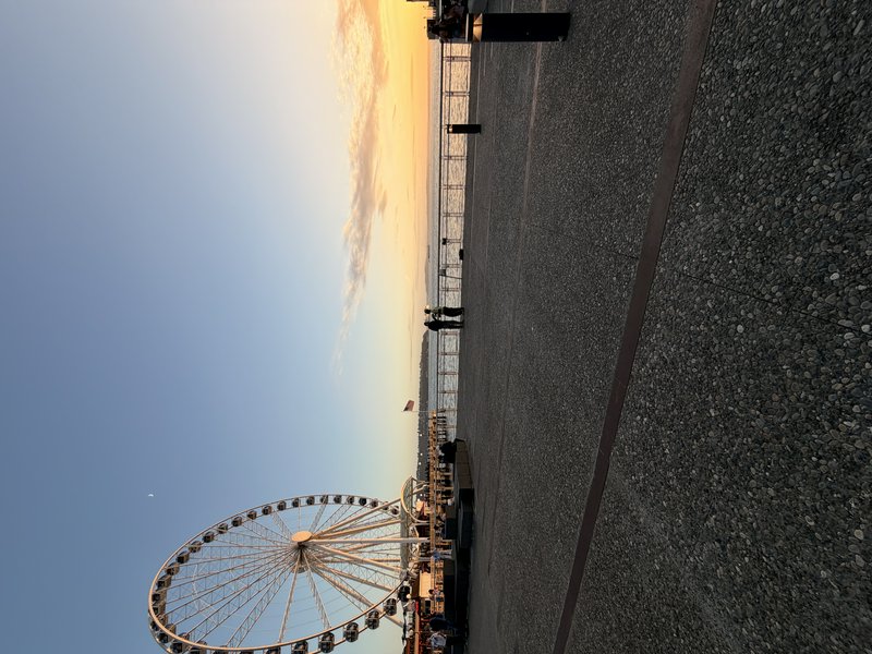 Seattle's iconic Great Wheel Ferris wheel on Elliott Bay's waterfront pier at golden sunset, with...