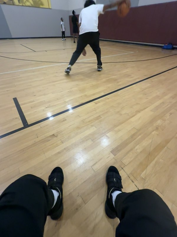 First-person POV from a basketball player on an indoor hardwood court, with another player dribbl...