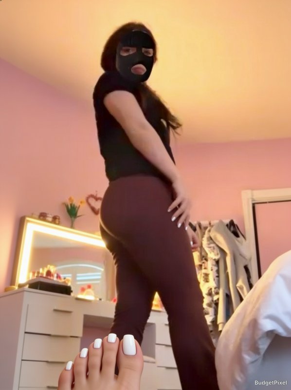 Forced perspective illusion photo making a woman in a balaclava appear to have an oversized foot ...
