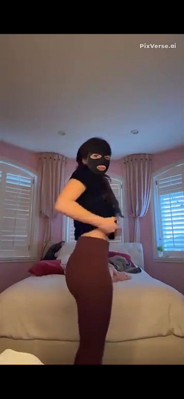 AI-generated figure wearing a black balaclava stands in a pastel pink bedroom in front of a tufte...