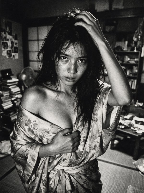 Grainy black and white portrait of young freckled East Asian woman in slipping floral kimono, han...