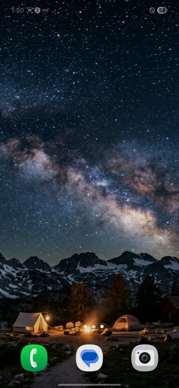 Night sky with the Milky Way over a mountain campsite with tents and a glowing campfire.