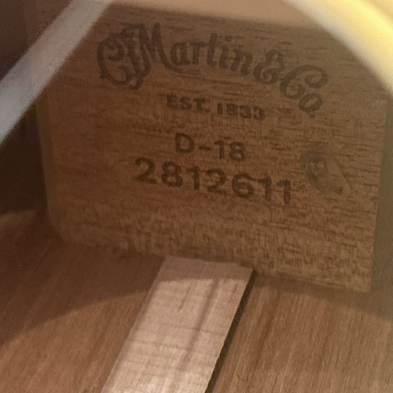 Close-up of a wooden stamp reading "Martin & Co" inside a guitar-wood interior.