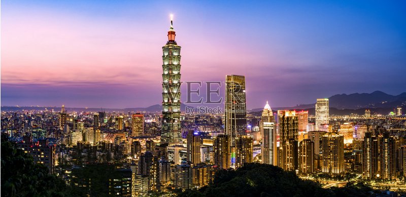 Taipei 101 and the illuminated Taipei skyline at dusk in a vibrant cityscape.